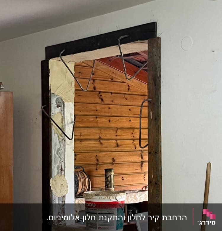 פח צבע וכלי עבודה בפתיחת קיר בשיפוץ